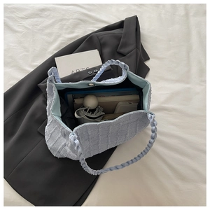 Détail du sac cabas matelassé bleu montrant sa grande capacité et ses anses tissées