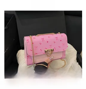 Close-up of pink crossbody bag showing floral pattern, metal buckle and gold chain