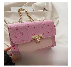 Close-up of pink floral crossbody bag featuring premium gold hardware and flap lock