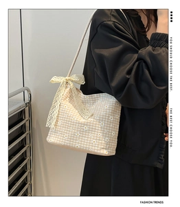 Detail of yellow gingham canvas tote with white floral embroidery and beige lace bow