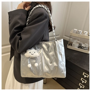 Detail of silver textured tote bag with braided handles and cloud charm ornament