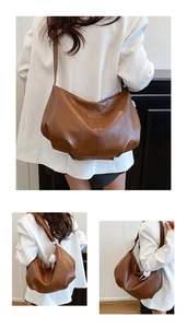 Detail of retro brown leather tote bag with lychee texture and soft plush ball accessory
