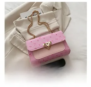 Pink crossbody bag detail showing cherry bow print and golden heart metal clasp
