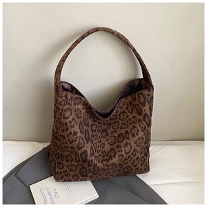 Detail of a large leopard print tote bag with soft suede texture on a minimalist surface