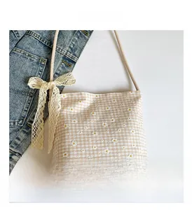 Detailed view of floral canvas tote bag with daisy embroidery and lace bow accent