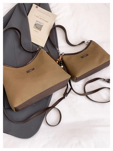 Detail of two-piece khaki canvas bucket bag set with dark brown leather trim and beads