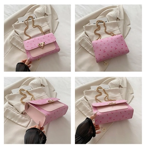 Detailed views of pink chain crossbody bag featuring cherry prints and golden heart buckle