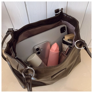Sac fourre-tout en cuir synthétique marron foncé montrant un intérieur spacieux