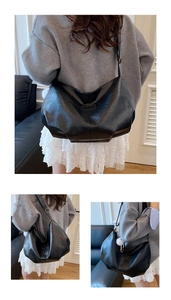 Macro view of a soft black PU leather hobo bag featuring a pleated design and logo detail