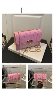 Detailed shot of pink floral crossbody bag with gold chain strap and bow print