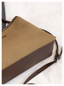 Detail of stitching and khaki fabric texture on the minimalist canvas bucket bag