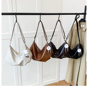 Detail showing vintage half-moon shoulder bags in cream, brown, coffee, and black tones