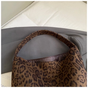 Detail view of leopard print faux suede tote bag with wide shoulder strap and soft texture