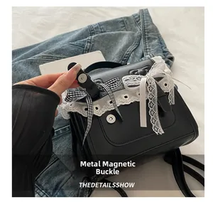 Dettaglio della chiusura magnetica in metallo su uno zaino nero con pizzo