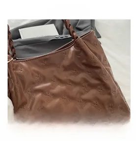 Detail of coffee brown tote bag with hollow bear patterns and woven handle design
