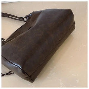 Vue détaillée du grand sac cabas marron foncé mat avec coutures et attaches métalliques
