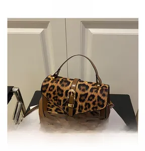 Detail showing leopard print texture with brown leather trim and golden metal clasp