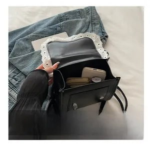 Dettaglio della capacità interna della borsa in ecopelle nera con bordo in pizzo bianco