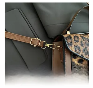 Macro shot of leopard print bag with golden adjustable metal buckle and strap details