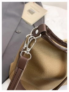 Detailed close-up of premium canvas stitching and silver metal hook on a bucket bag
