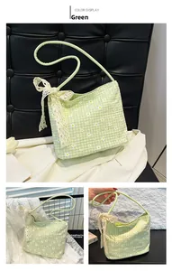 Detail of green plaid shoulder bag with daisy prints and large lace bow decoration