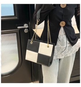 Détail du sac cabas à carreaux noir et blanc avec bretelles à chaîne dorée brillante