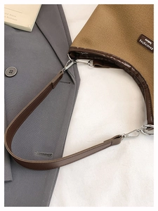 Detailed top view of canvas bucket bag with leather trim and silver metal buckles