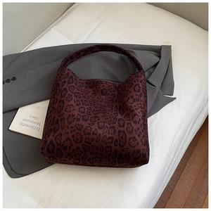 Macro shot of dark red leopard print tote bag fabric and wide integrated strap detail