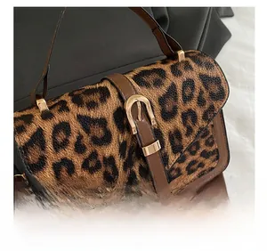 Detailed view of leopard print texture and vintage buckle on brown leather crossbody bag