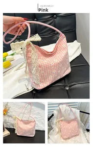Detailed view of a pink floral underarm bag featuring a delicate white lace bow and canvas texture