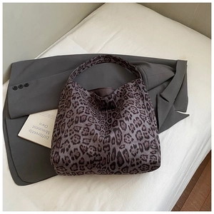 Detail view of the canvas tote bag showing retro leopard print texture and wide handle