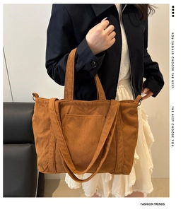 Detailed close-up of brown corduroy tote bag showing striped texture and front pocket