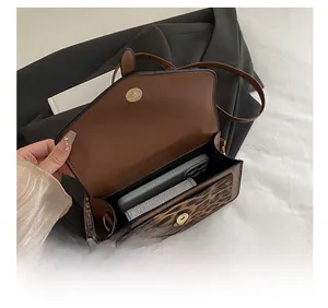 Detail view of the brown leopard print crossbody bag showing interior storage capacity