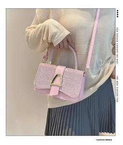 Détail du sac à bandoulière à paillettes roses avec boucle dorée en D sur tenue en maille