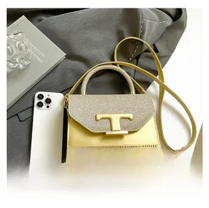 Detailed macro view of yellow mini crossbody bag with signature golden T-shaped buckle
