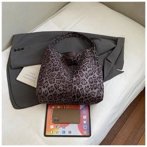 Flat lay of a leopard print tote bag showing spacious interior with tablet and phone
