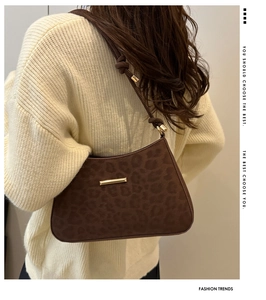 Détail du sac à bandoulière imprimé léopard avec boucle dorée et sangle nouée