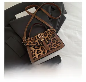 Detail of brown leather handbag with leopard print pony hair flap and top handle