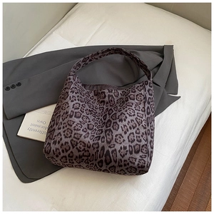 Detail shot of leopard print canvas tote bag with a soft texture on white bedding background