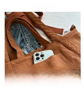 Detail of caramel brown corduroy tote bag showing front pocket and thick ribbed texture