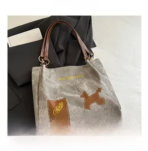 Détail du cabas en toile vintage avec anses en cuir et texte Tidal Dryness