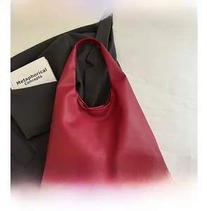 Close-up of burgundy lychee grain leather tote bag with elegant draped hobo structure