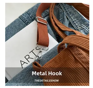 Close-up of durable metal hardware hook on brown corduroy tote bag with strap