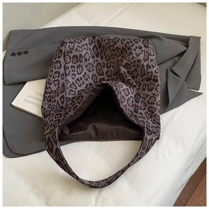 Detailed top view of large leopard print tote bag with dark brown lining on white fabric
