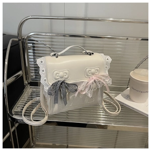Dettaglio borsa in pelle PU bianca con bordi in pizzo, fiocchi e nastri decorativi