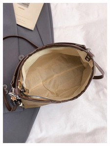 Internal view of brown canvas shoulder bag with leather trim and beaded pendant detail
