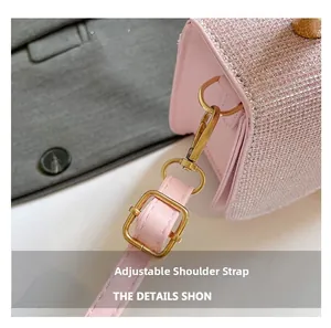 Détail de la bandoulière réglable en cuir rose avec boucle dorée et paillettes roses