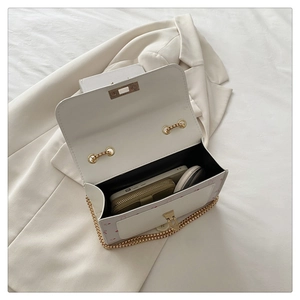 Internal view of a white leather crossbody bag showing storage space for a phone and cardholder