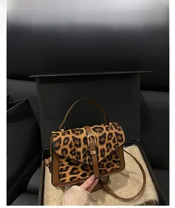 Detail of coffee brown leopard print handbag with metallic closure and leather trim