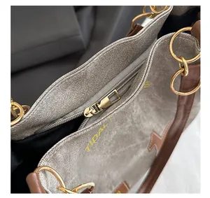 Détail de la fermeture éclair dorée et doublure en tissu d'un grand sac cabas marron